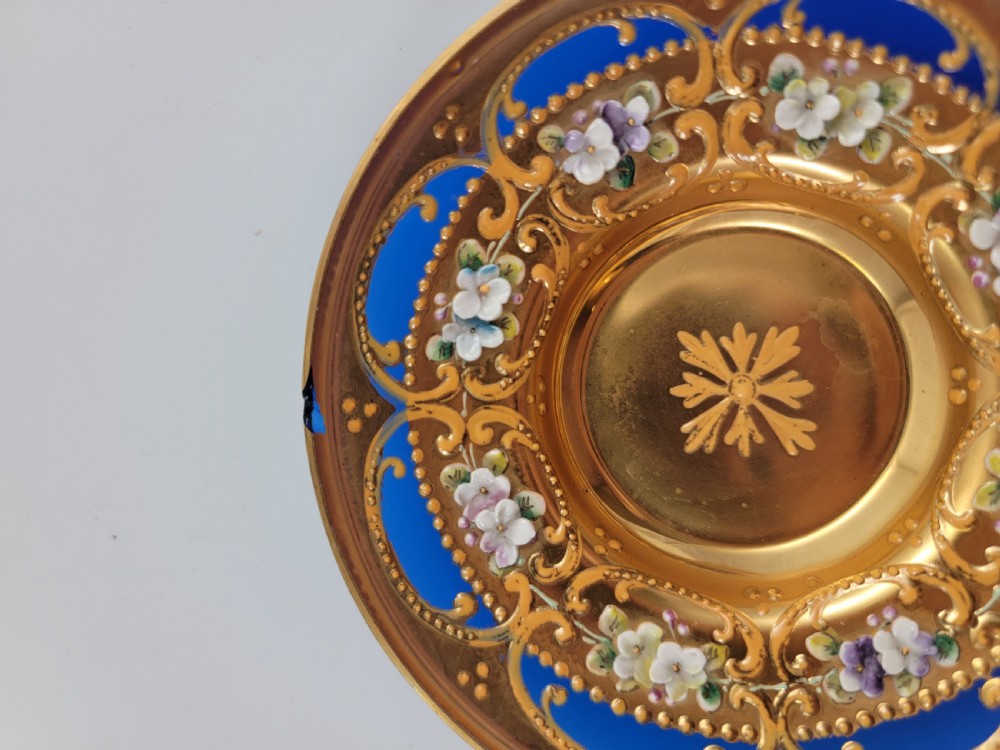 A set of six late nineteenth-century cobalt blue Bohemian glass tea cups and saucers featuring heavy gold gilding and raised enamel floral decoration. View X