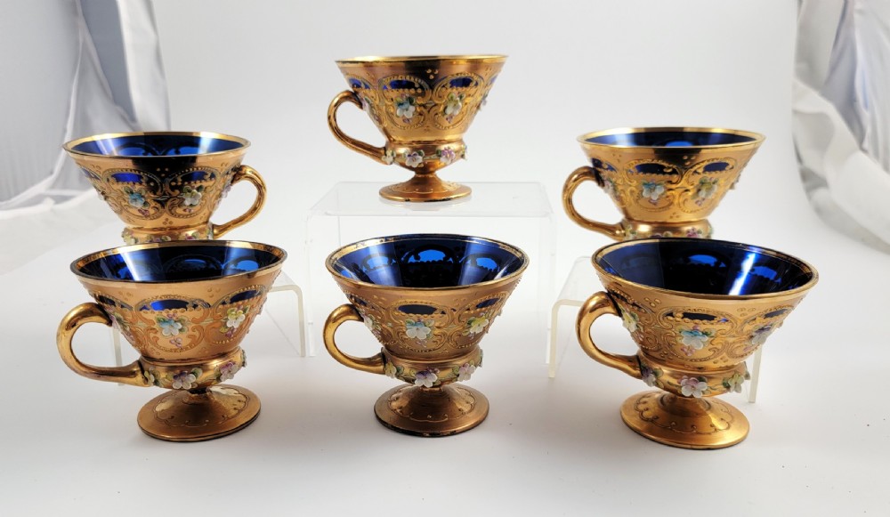 A set of six late nineteenth-century cobalt blue Bohemian glass tea cups and saucers featuring heavy gold gilding and raised enamel floral decoration. View XII
