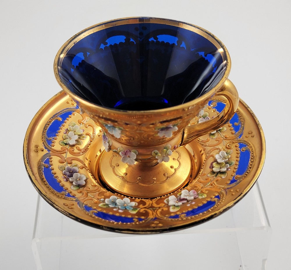 A set of six late nineteenth-century cobalt blue Bohemian glass tea cups and saucers featuring heavy gold gilding and raised enamel floral decoration. View XV