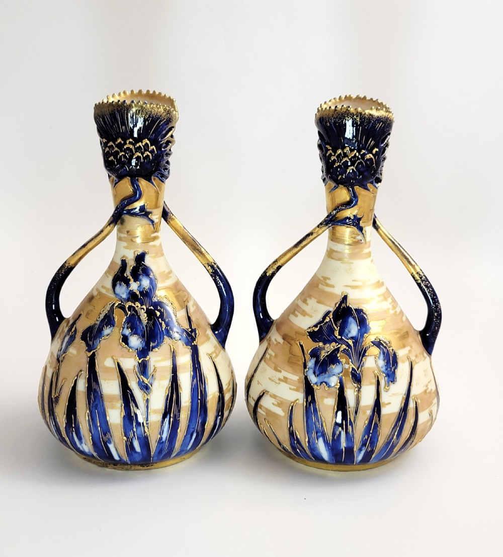 A pair of Art Nouveau porcelain vases featuring hand-painted cobalt blue iris flowers, gold-toned striped backgrounds, and gilded sweeping handles. View III