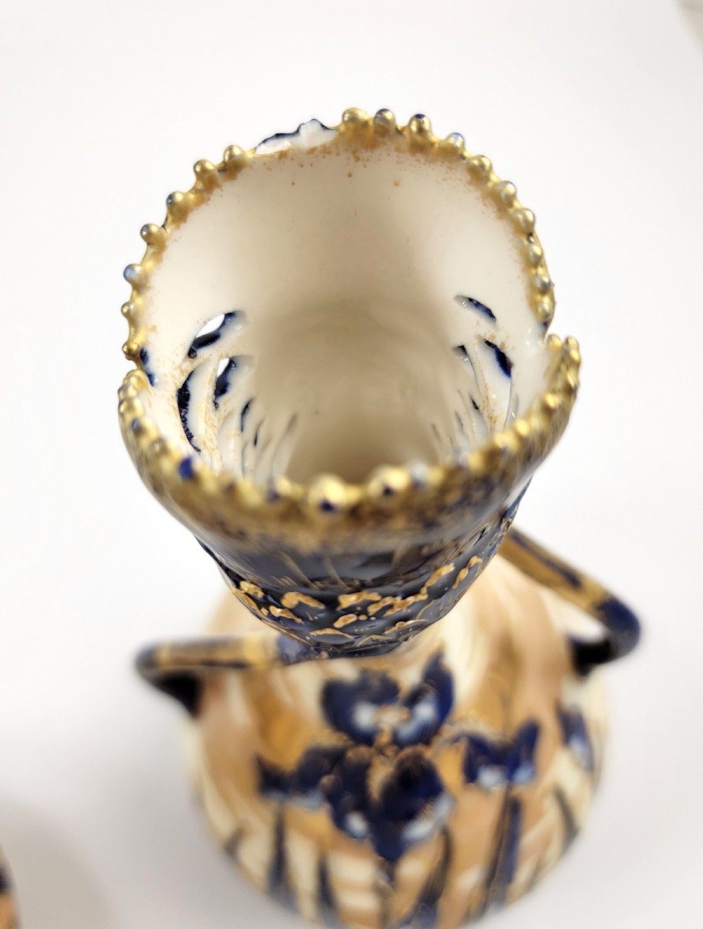 A pair of Art Nouveau porcelain vases featuring hand-painted cobalt blue iris flowers, gold-toned striped backgrounds, and gilded sweeping handles. View VIII