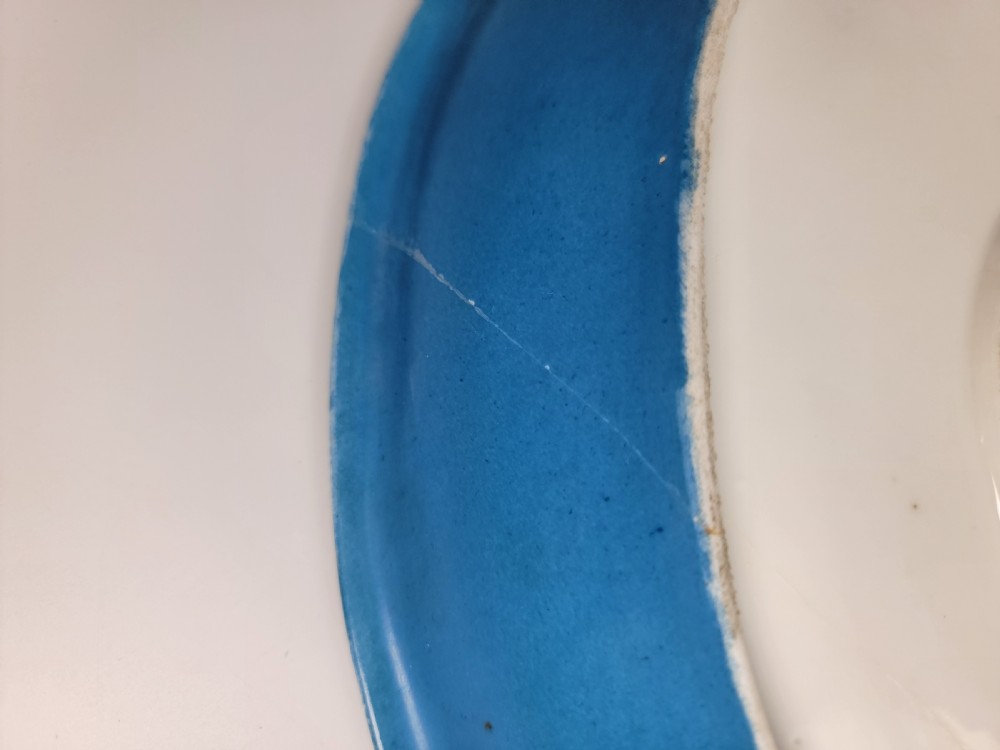 An oval French porcelain tray featuring a bleu celeste ground with hand-painted floral reserves and a central scene depicting figures in a landscape enclosed by gilt ornamentation. View VI