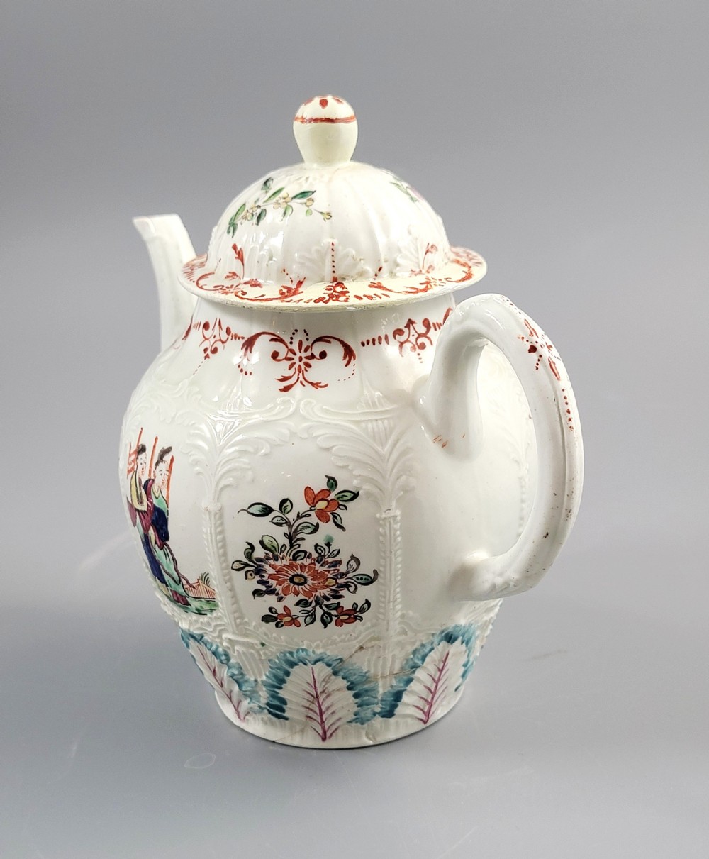 A Georgian soft-paste porcelain teapot decorated with hand-painted Chinoiserie figures, floral sprays, and moulded leaf work around the base. View II