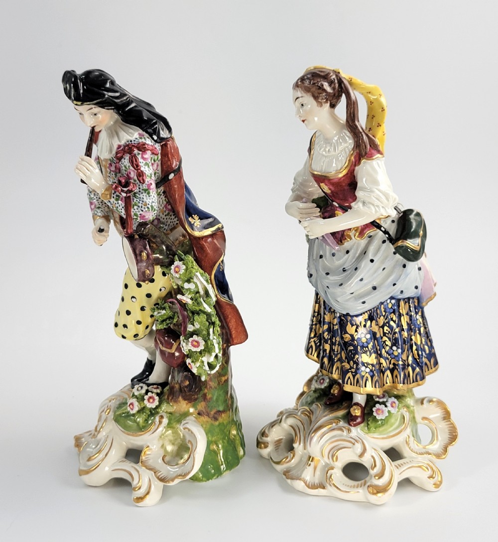 A pair of 19th-century French Samson porcelain figures depicting a male musician with a pipe and drum alongside a female musician holding a triangle, set on gilded rococo scrollwork bases. View II