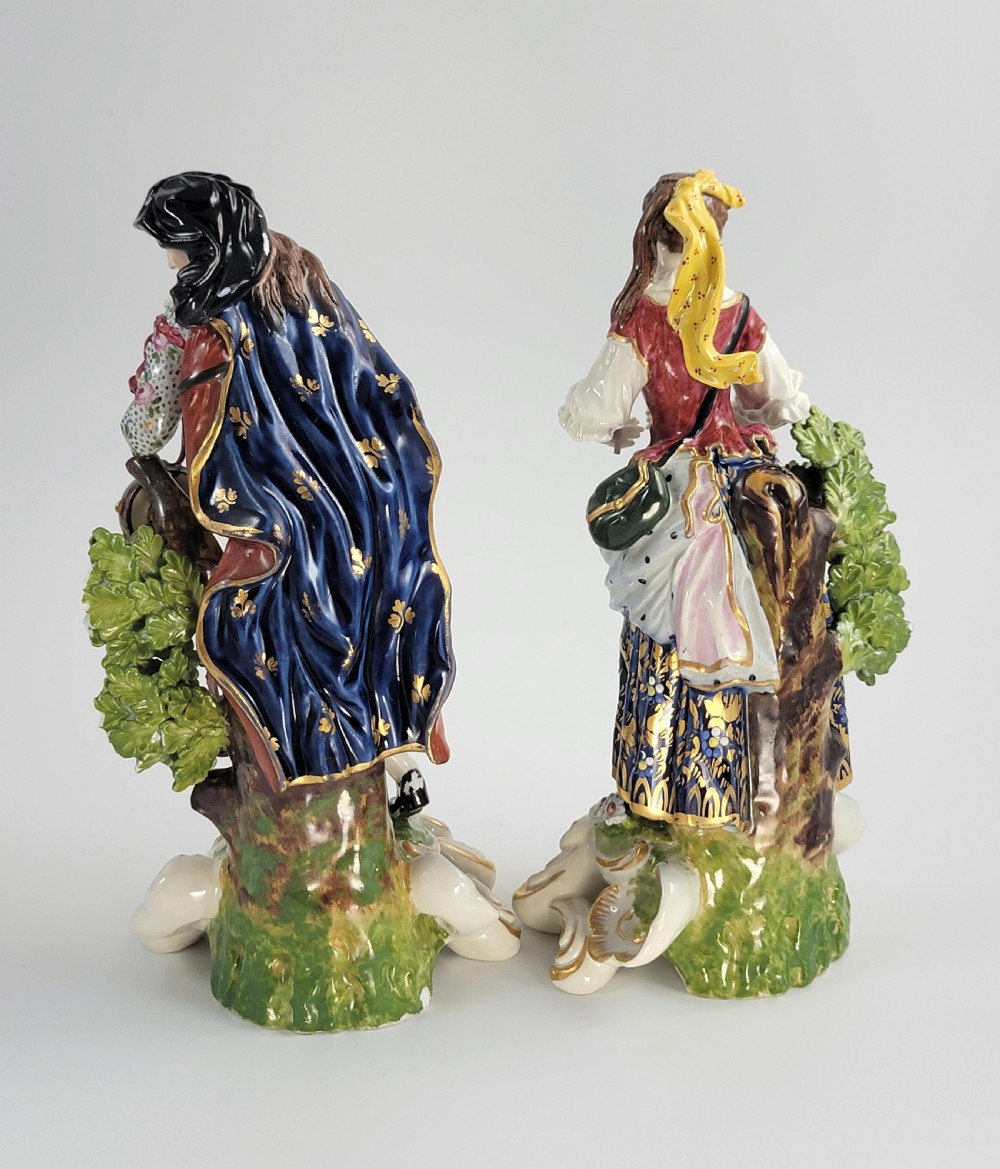 A pair of 19th-century French Samson porcelain figures depicting a male musician with a pipe and drum alongside a female musician holding a triangle, set on gilded rococo scrollwork bases. View III