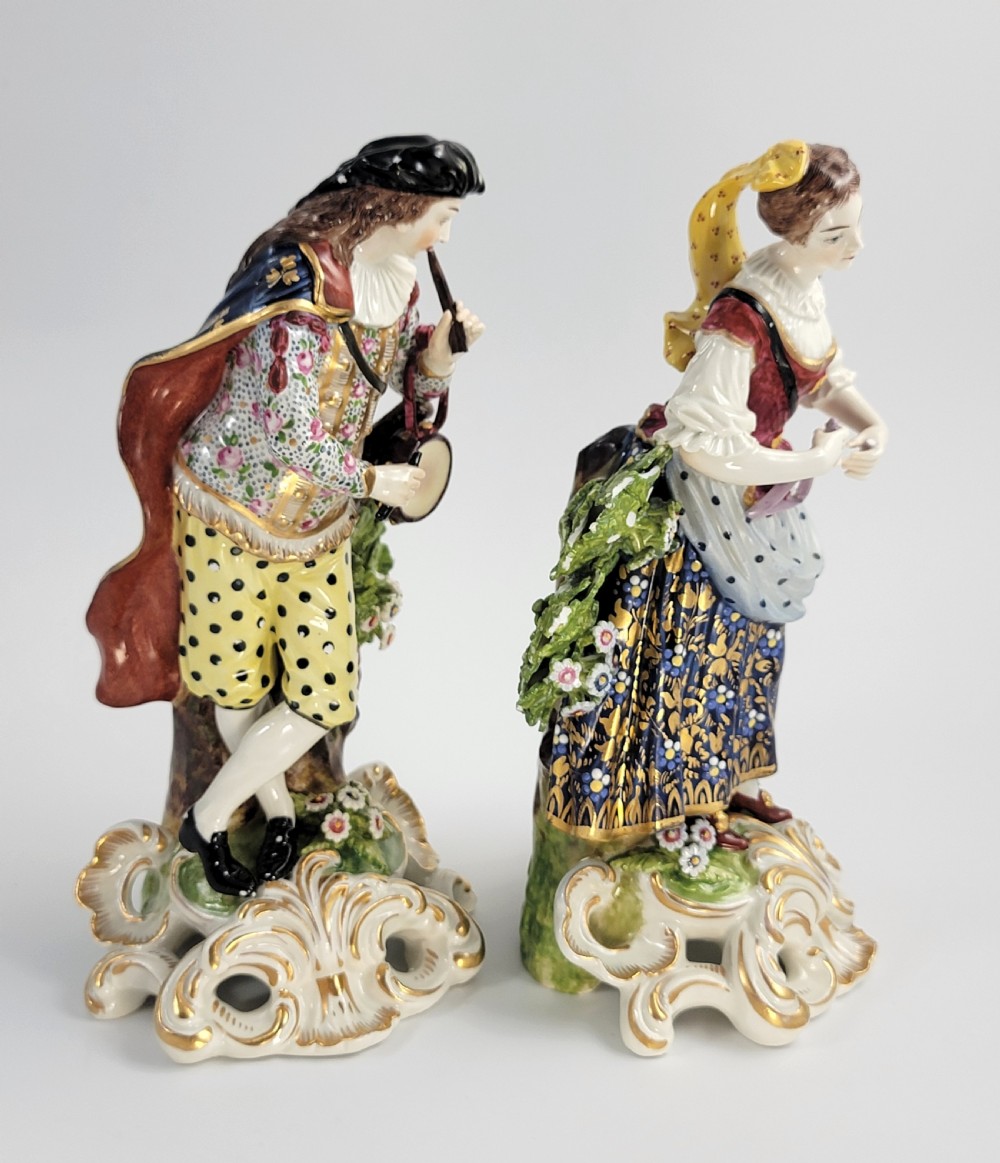 A pair of 19th-century French Samson porcelain figures depicting a male musician with a pipe and drum alongside a female musician holding a triangle, set on gilded rococo scrollwork bases. View V