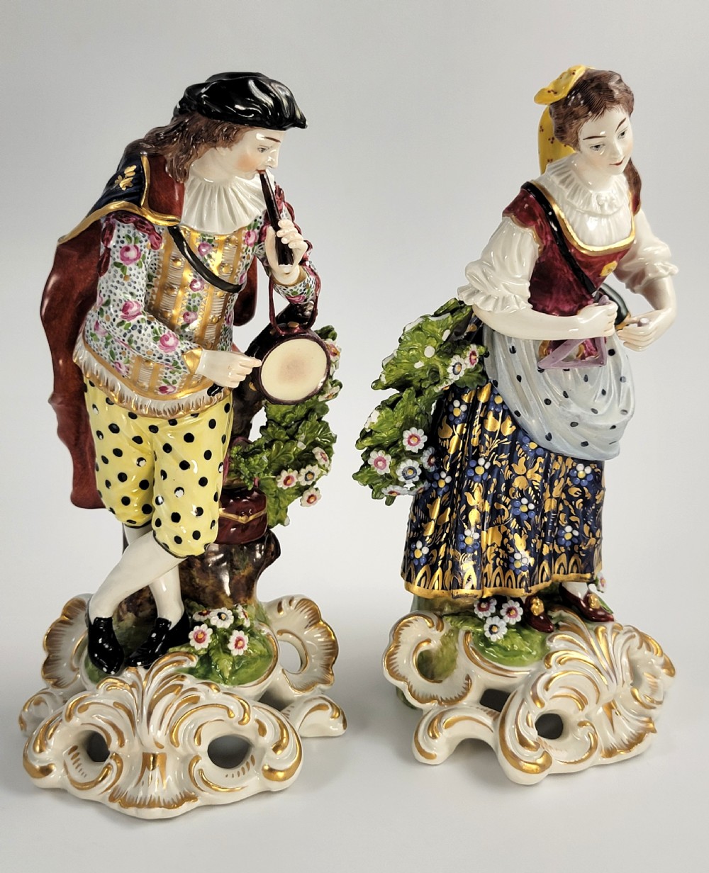 A pair of 19th-century French Samson porcelain figures depicting a male musician with a pipe and drum alongside a female musician holding a triangle, set on gilded rococo scrollwork bases. View VI