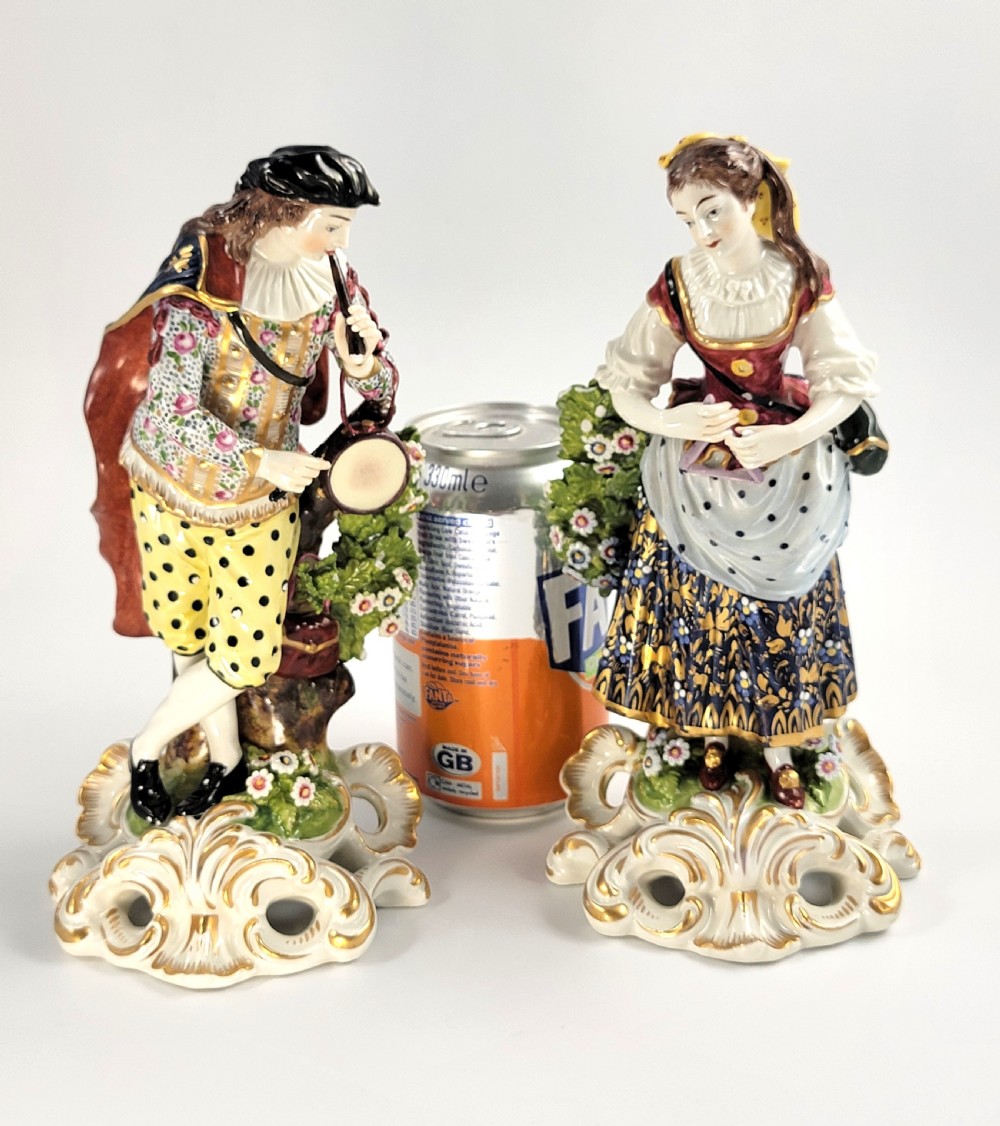 A pair of 19th-century French Samson porcelain figures depicting a male musician with a pipe and drum alongside a female musician holding a triangle, set on gilded rococo scrollwork bases. View VIII