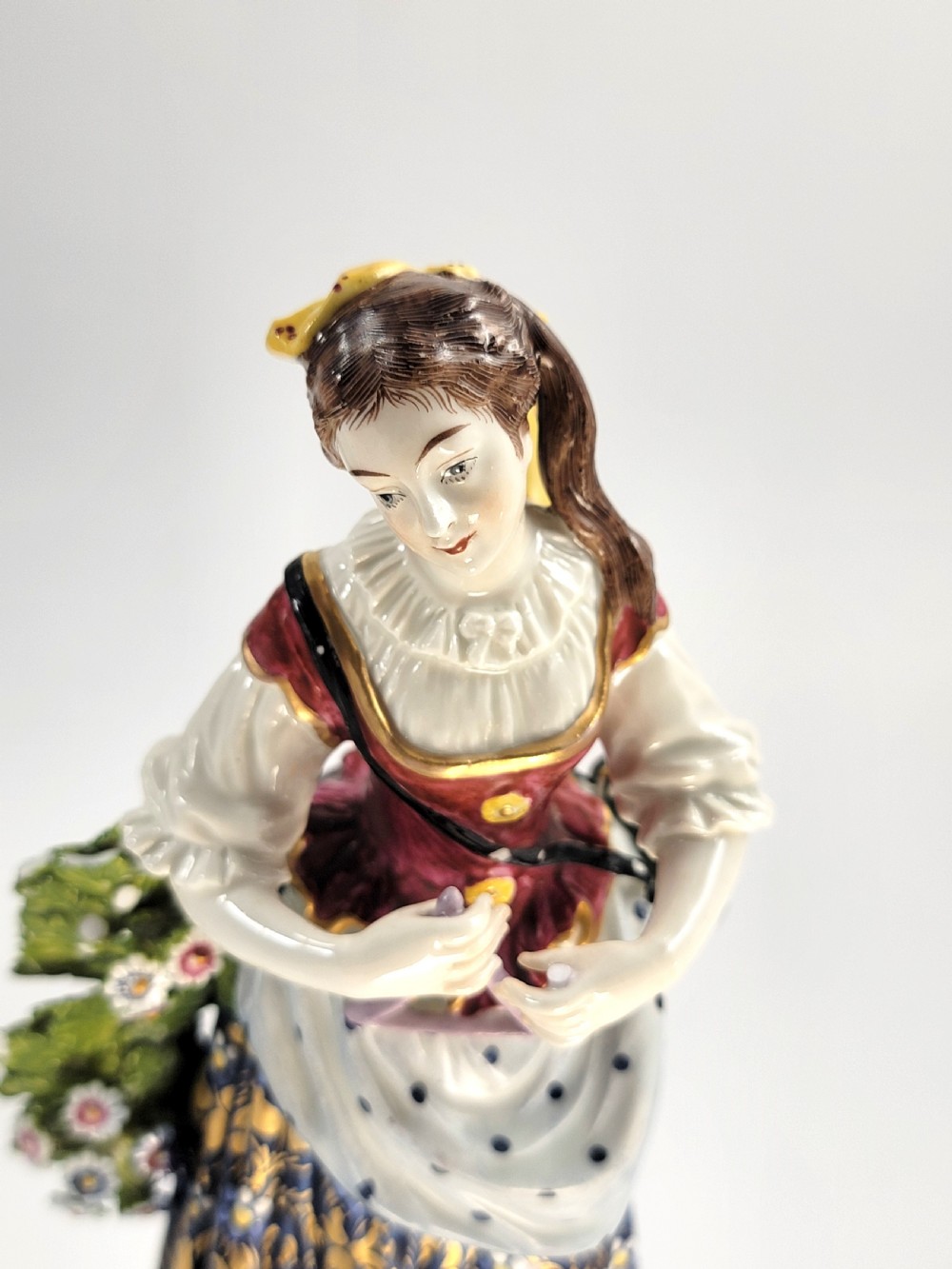 A pair of 19th-century French Samson porcelain figures depicting a male musician with a pipe and drum alongside a female musician holding a triangle, set on gilded rococo scrollwork bases. View IX