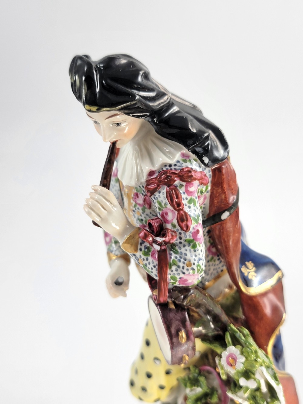 A pair of 19th-century French Samson porcelain figures depicting a male musician with a pipe and drum alongside a female musician holding a triangle, set on gilded rococo scrollwork bases. View X