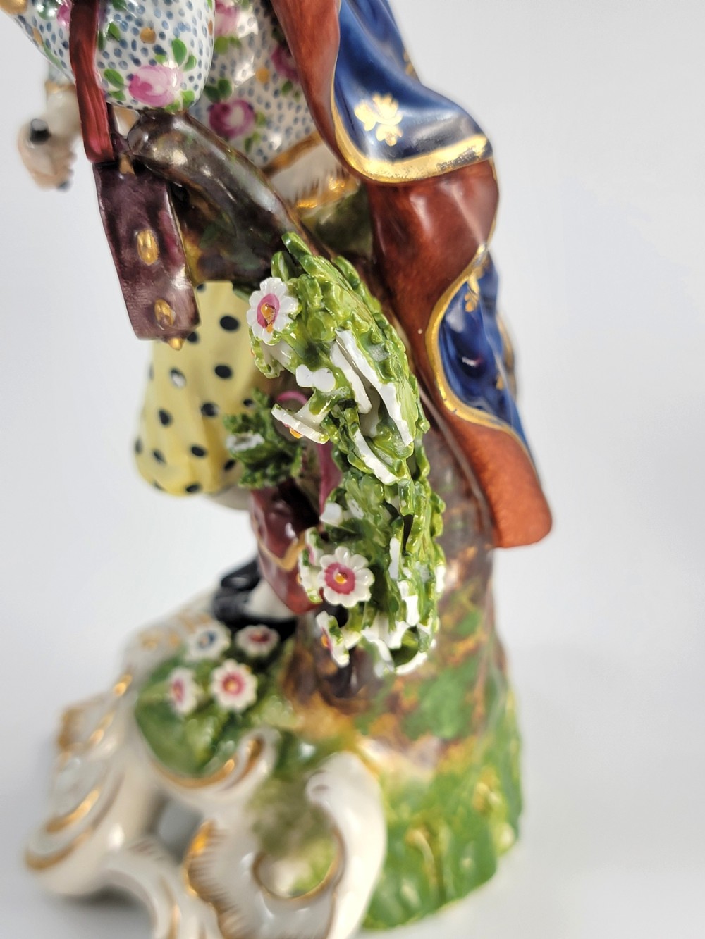 A pair of 19th-century French Samson porcelain figures depicting a male musician with a pipe and drum alongside a female musician holding a triangle, set on gilded rococo scrollwork bases. View XI