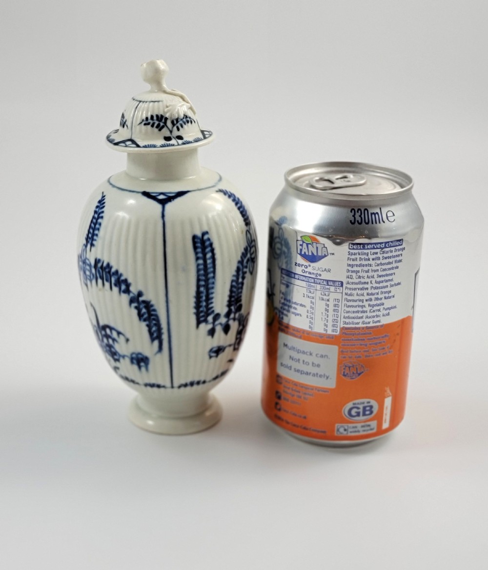 An eighteenth-century fluted soft-paste porcelain tea canister featuring underglaze blue floral patterns and a matching lid with a flower bud finial. View XII