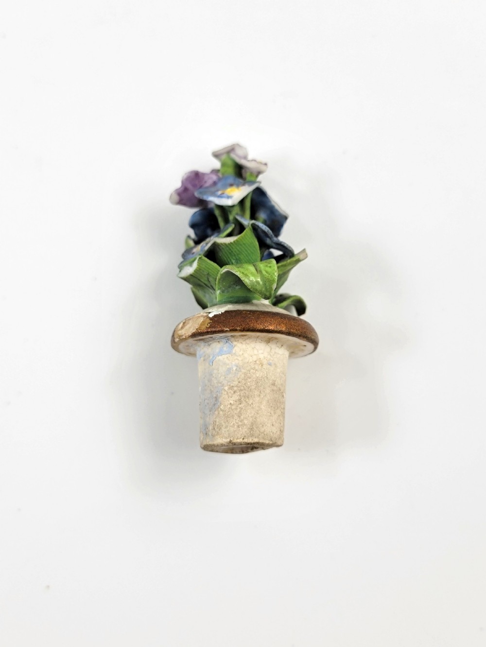 A gourd-shaped white porcelain scent bottle decorated with applied forget-me-not flowers, green vines, hand-painted insects, and a floral stopper. View IX