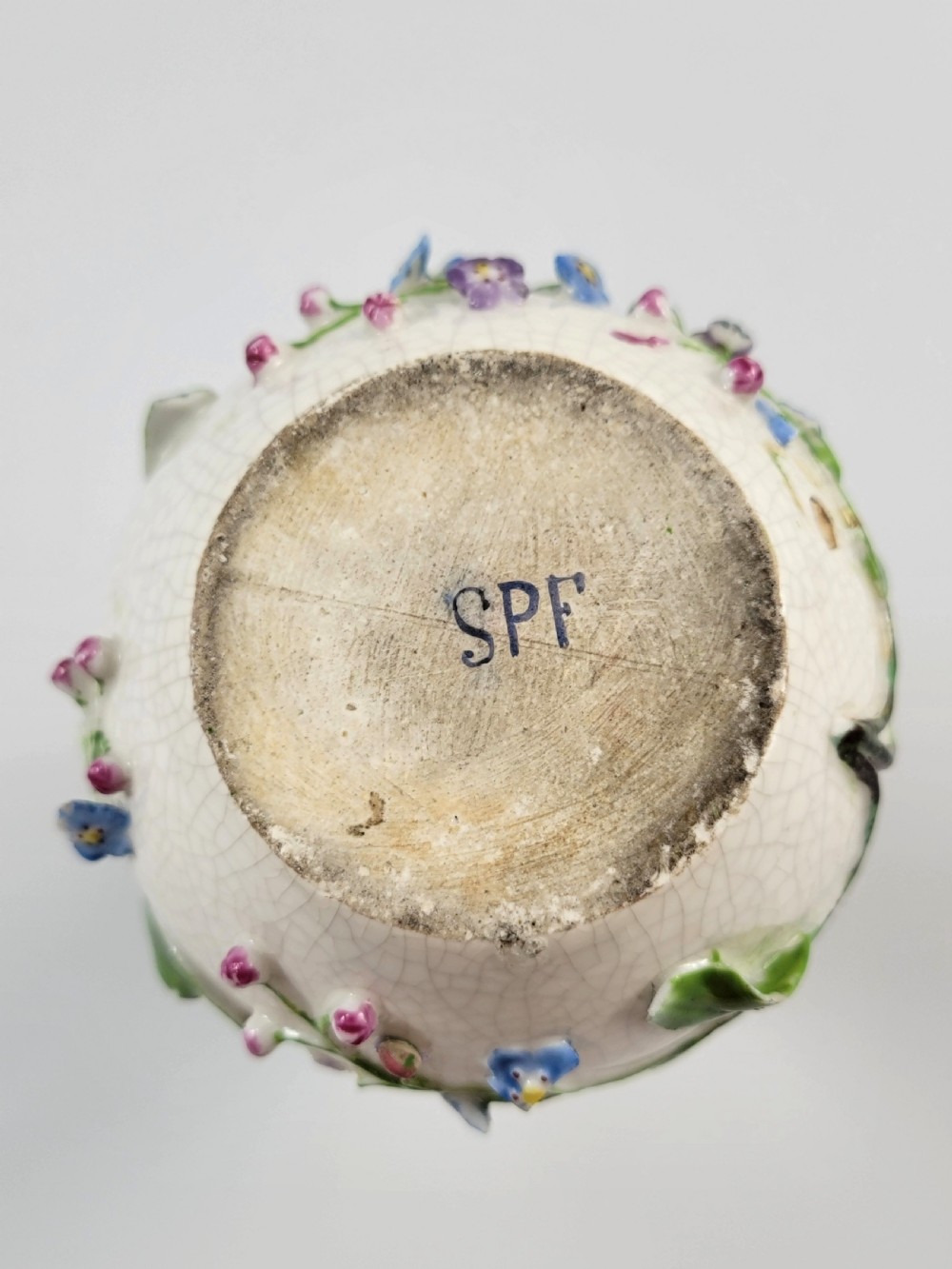 A gourd-shaped white porcelain scent bottle decorated with applied forget-me-not flowers, green vines, hand-painted insects, and a floral stopper. View X