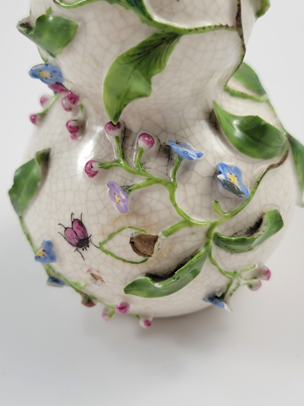 A gourd-shaped white porcelain scent bottle decorated with applied forget-me-not flowers, green vines, hand-painted insects, and a floral stopper. View XI