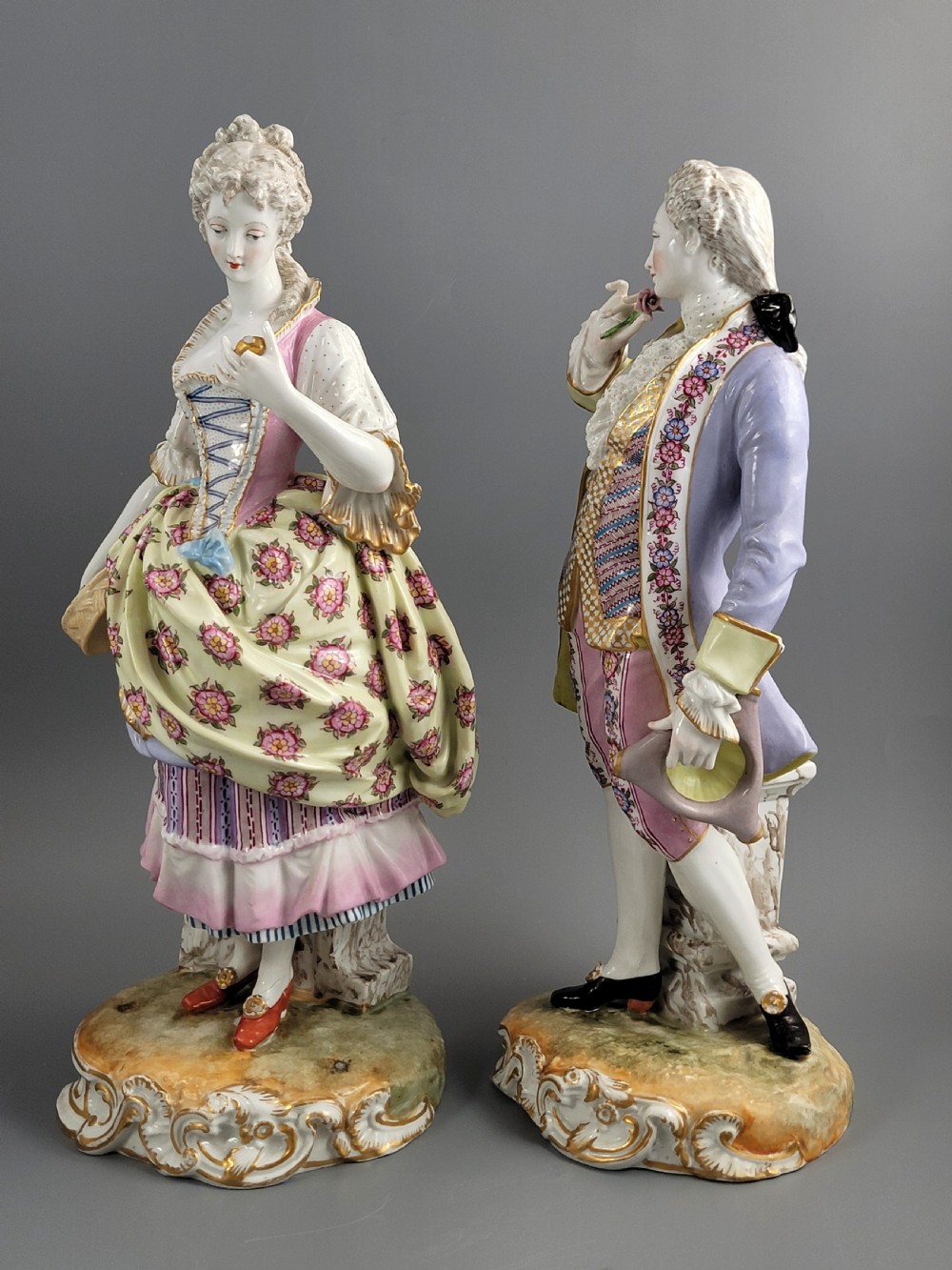 A pair of 18th-century German hard-paste porcelain figurines depicting a gentleman and lady in court dress on gilded bases. View II