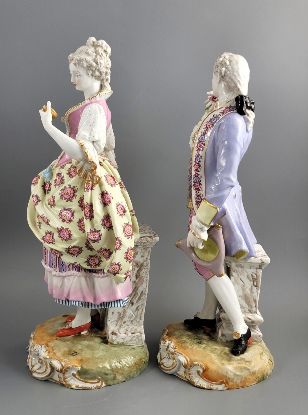 A pair of 18th-century German hard-paste porcelain figurines depicting a gentleman and lady in court dress on gilded bases. View III