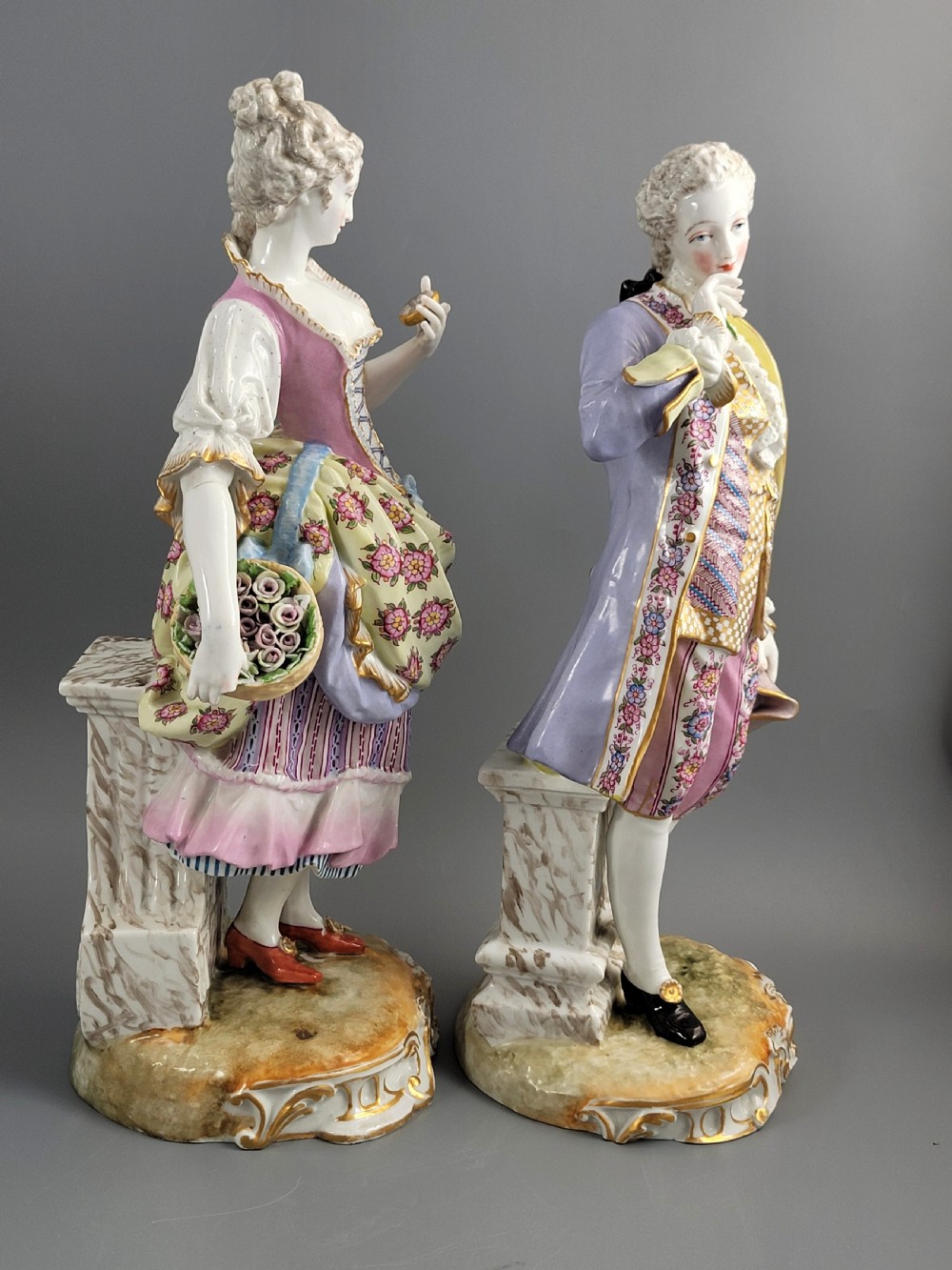 A pair of 18th-century German hard-paste porcelain figurines depicting a gentleman and lady in court dress on gilded bases. View VII