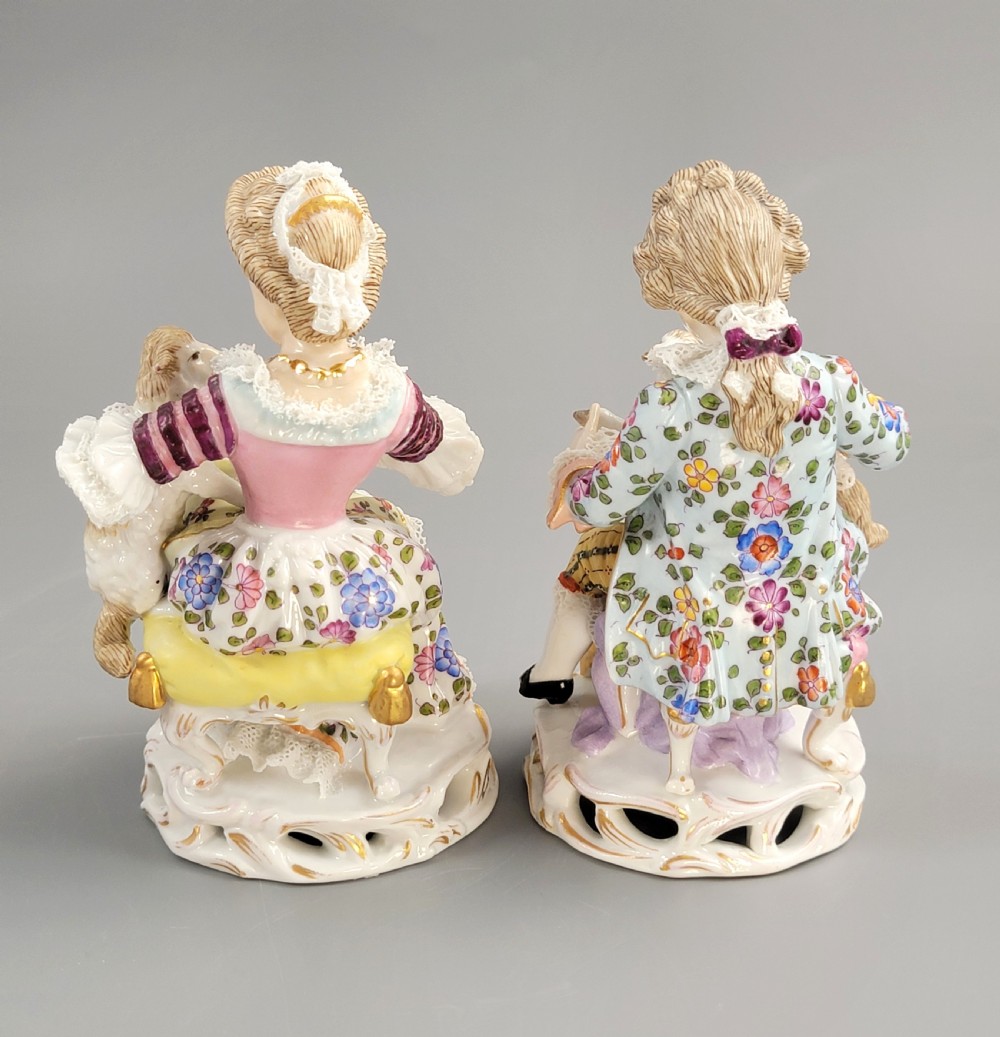 A pair of late 19th-century Sitzendorf porcelain figurines depicting a boy and girl in 18th-century clothing seated with pet lambs on gilded scrollwork bases. View III