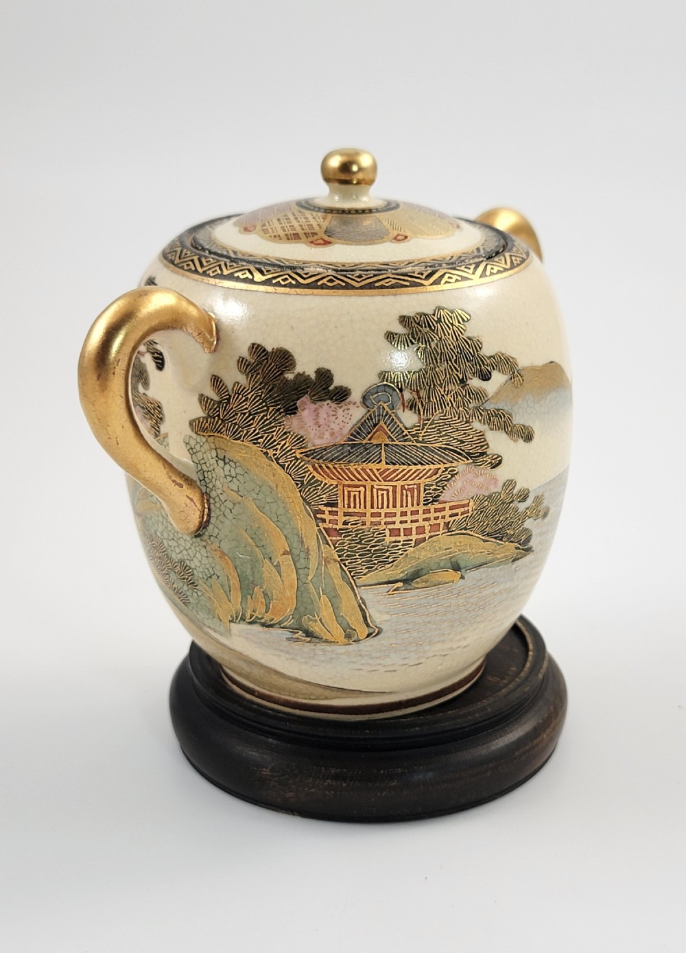 A lidded Japanese Satsuma ceramic sugar bowl with two gilt handles, crackle glaze, and hand-painted figures in a landscape. View III