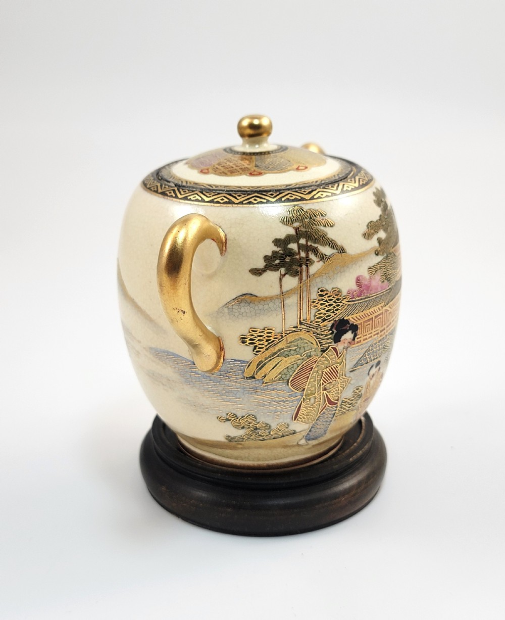 A lidded Japanese Satsuma ceramic sugar bowl with two gilt handles, crackle glaze, and hand-painted figures in a landscape. View VI