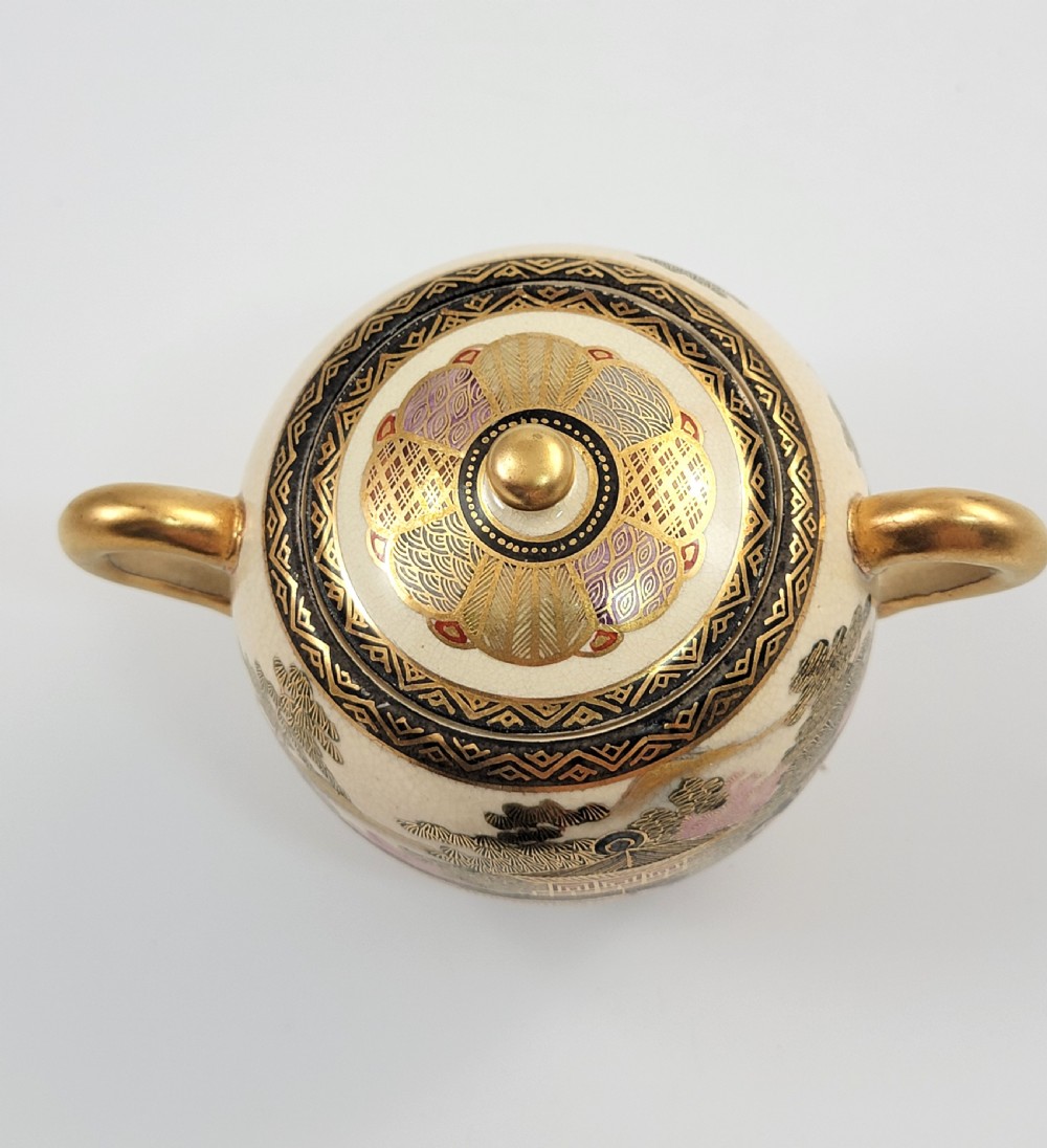 A lidded Japanese Satsuma ceramic sugar bowl with two gilt handles, crackle glaze, and hand-painted figures in a landscape. View VII
