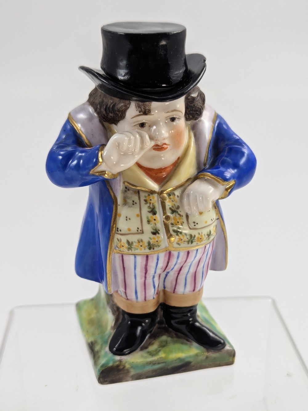A porcelain Toby jug depicting a gentleman in a black top hat, blue coat, and striped trousers taking snuff. View VI
