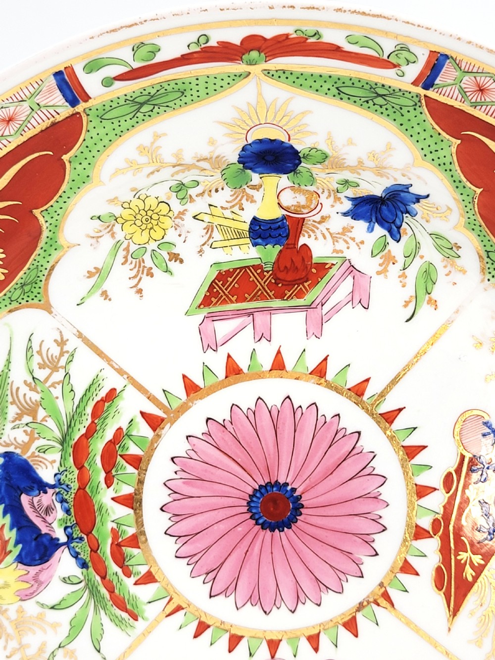 A circular antique English porcelain dessert plate decorated with hand-painted Chinoiserie panels, mythical dragons, and a pink central flower motif. View VI