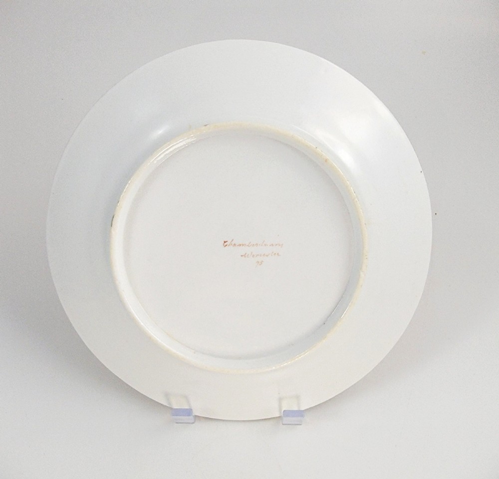 A circular antique English porcelain dessert plate decorated with hand-painted Chinoiserie panels, mythical dragons, and a pink central flower motif. View X