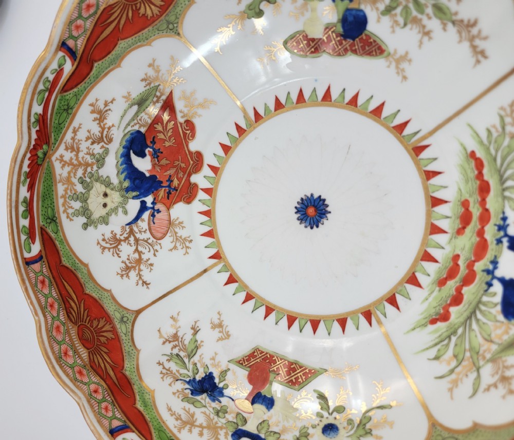 A Regency Chamberlain Worcester porcelain bowl with scalloped edges and colourful Chinoiserie enamel painting, resting on a carved dark mahogany stand. View XII