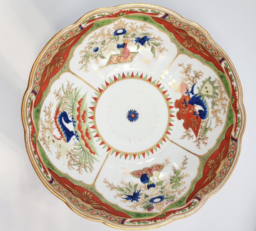 A Regency Chamberlain Worcester porcelain bowl with scalloped edges and colourful Chinoiserie enamel painting, resting on a carved dark mahogany stand. View XV
