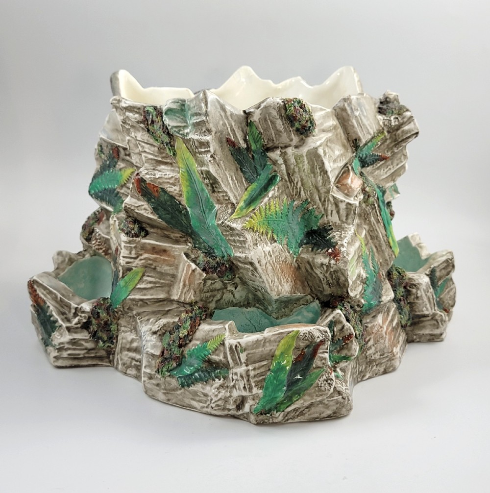 A Victorian Royal Worcester majolica ceramic jardiniere modelled as realistic rockwork with green fern fronds and moss detailing.