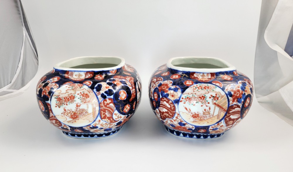 A pair of oval Japanese Imari porcelain jardinieres decorated with cobalt blue, iron red, and floral reserve panels. View II