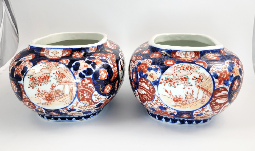 A pair of oval Japanese Imari porcelain jardinieres decorated with cobalt blue, iron red, and floral reserve panels. View III
