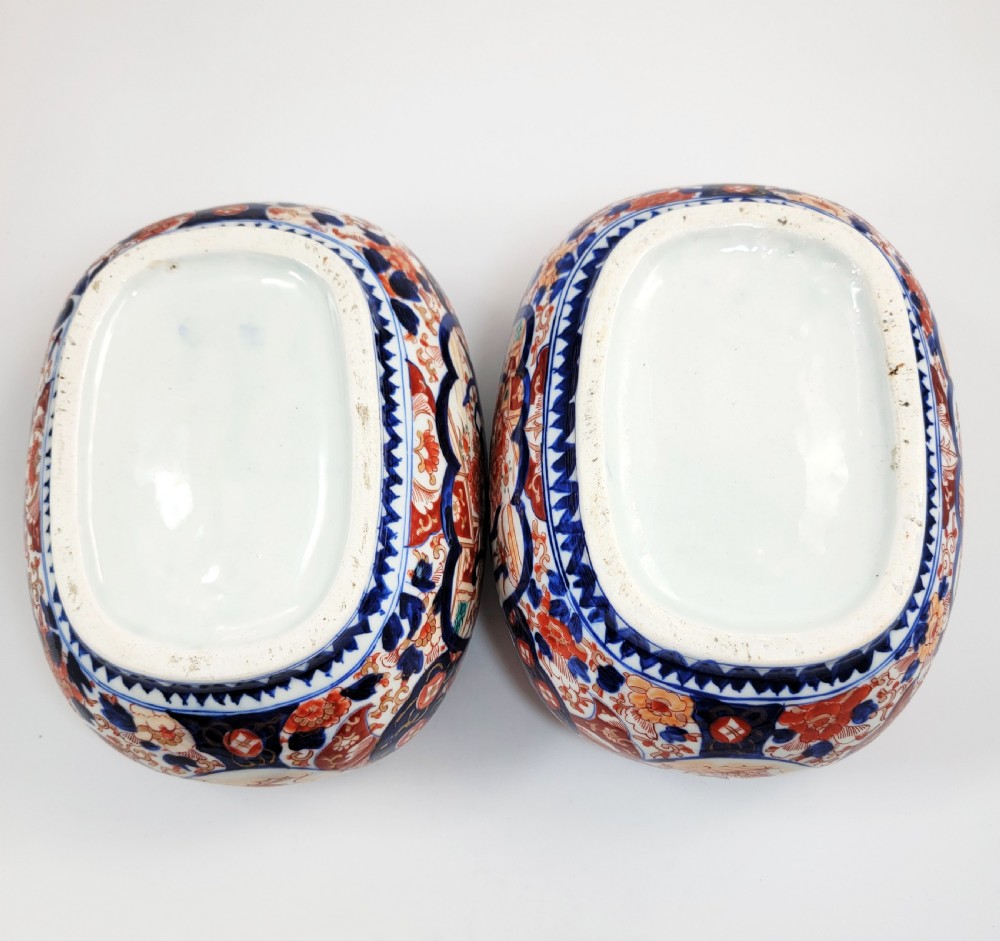 A pair of oval Japanese Imari porcelain jardinieres decorated with cobalt blue, iron red, and floral reserve panels. View VII