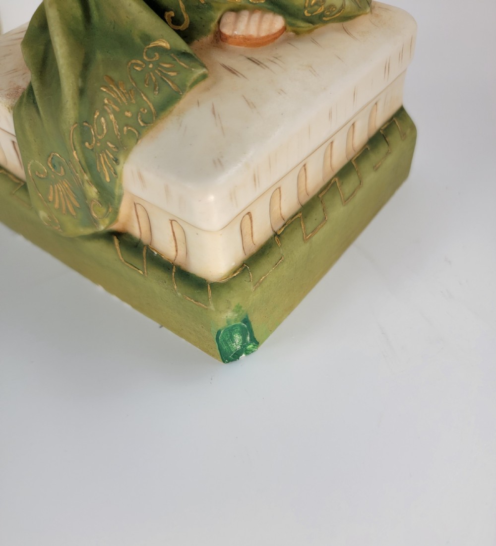 A pair of antique porcelain figures depicting a male and female in draped green and pink classical robes holding musical instruments. View XII