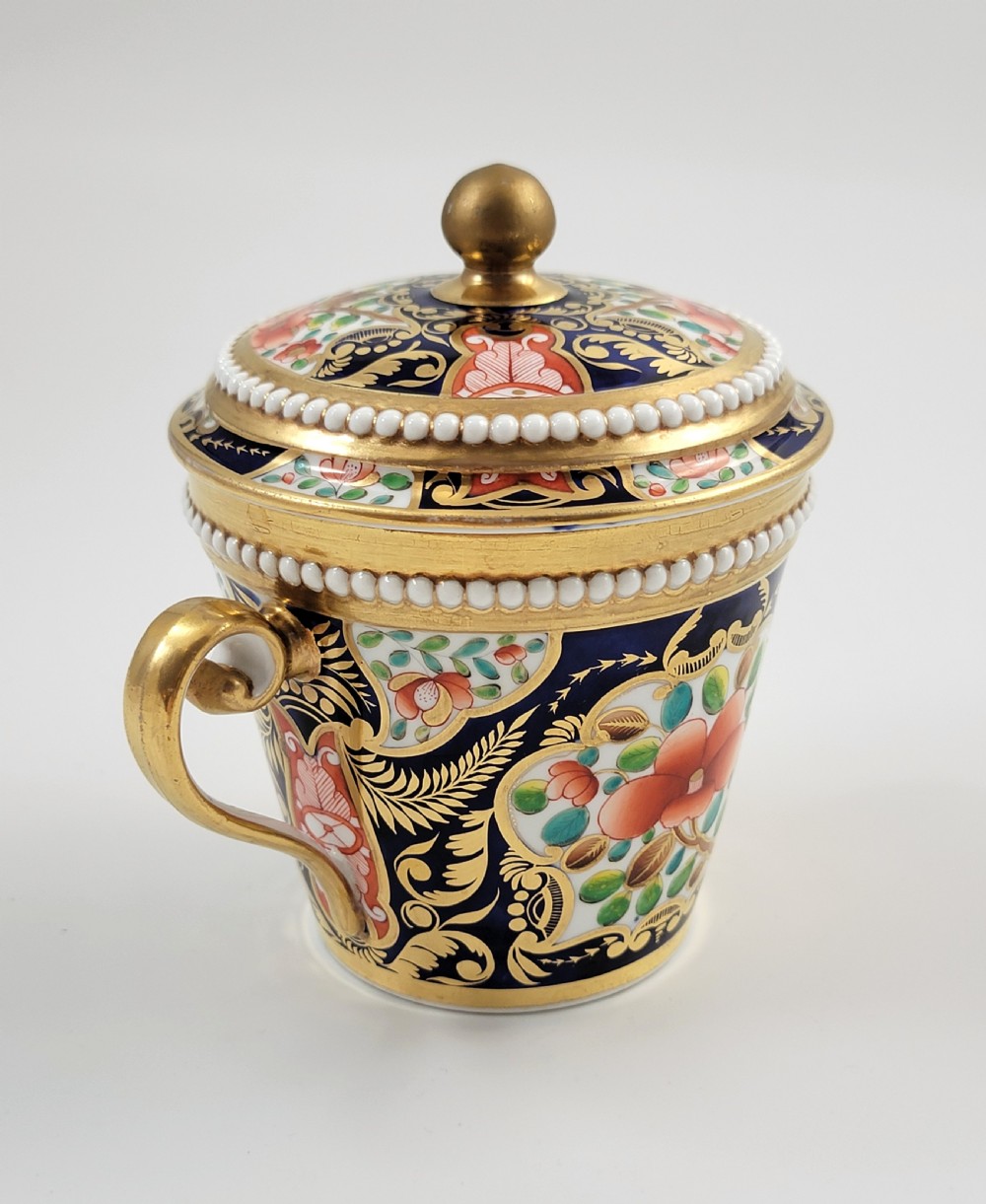 An antique porcelain chocolate cup and lid decorated with cobalt blue and gold Imari floral panels and raised white pearl borders. View III