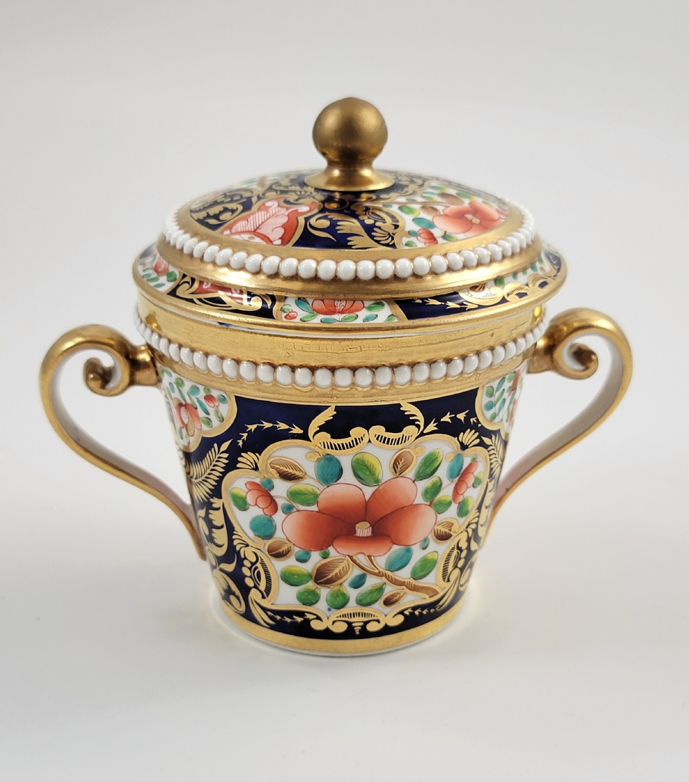 An antique porcelain chocolate cup and lid decorated with cobalt blue and gold Imari floral panels and raised white pearl borders. View IV