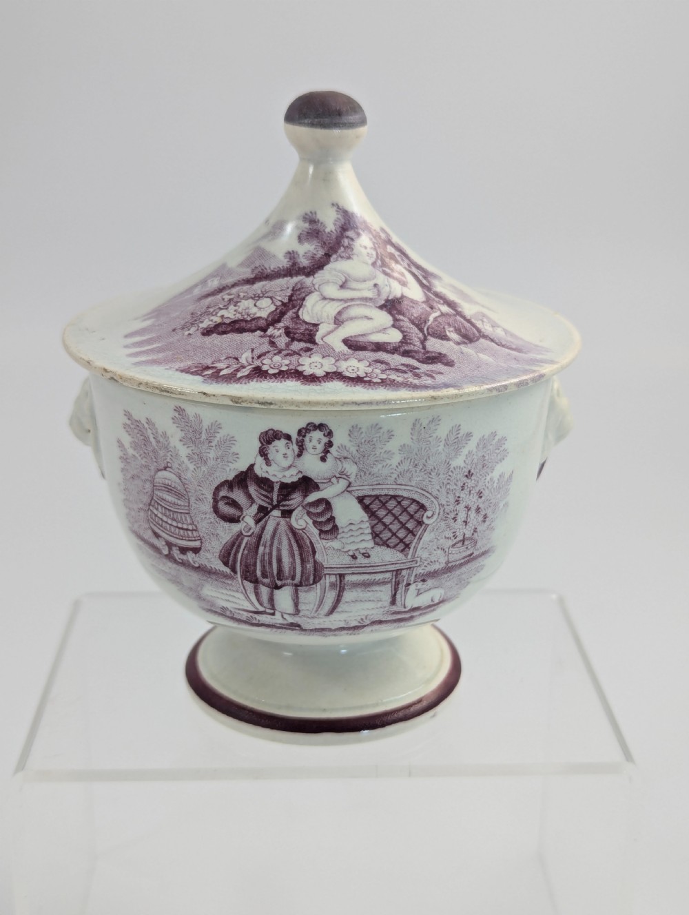 A 19th-century Staffordshire covered earthenware sugar bowl featuring a purple mulberry transferware romantic scene with lion mask handles and a pointed lid. View III