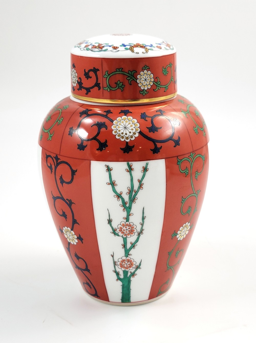 A hand-painted Herend porcelain tea caddy featuring vibrant red Siang Rouge panels, intricate floral vine motifs, and a matching domed lid.