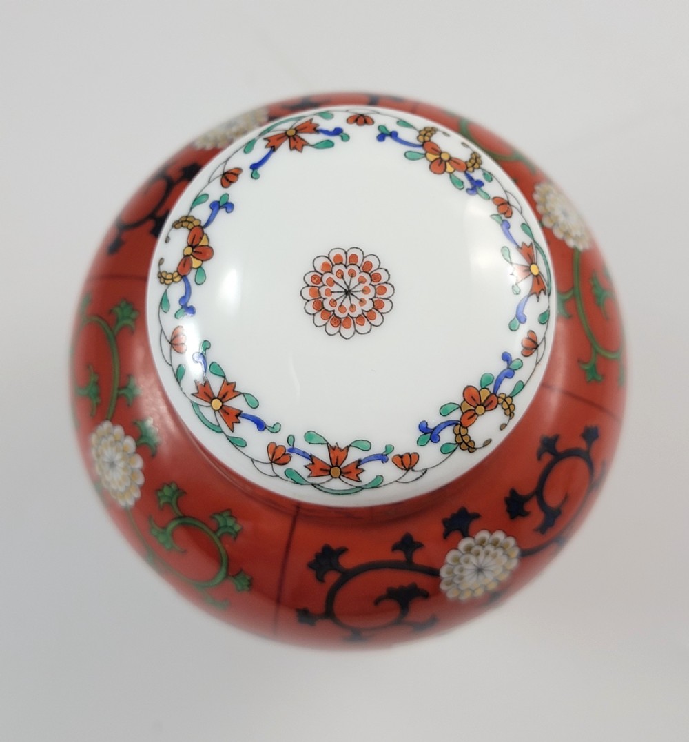 A hand-painted Herend porcelain tea caddy featuring vibrant red Siang Rouge panels, intricate floral vine motifs, and a matching domed lid. View VIII