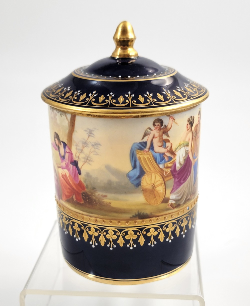 A cobalt blue porcelain covered cup featuring gold leaf scrollwork trim and a hand-painted allegorical woodland vignette with classical figures. View IV
