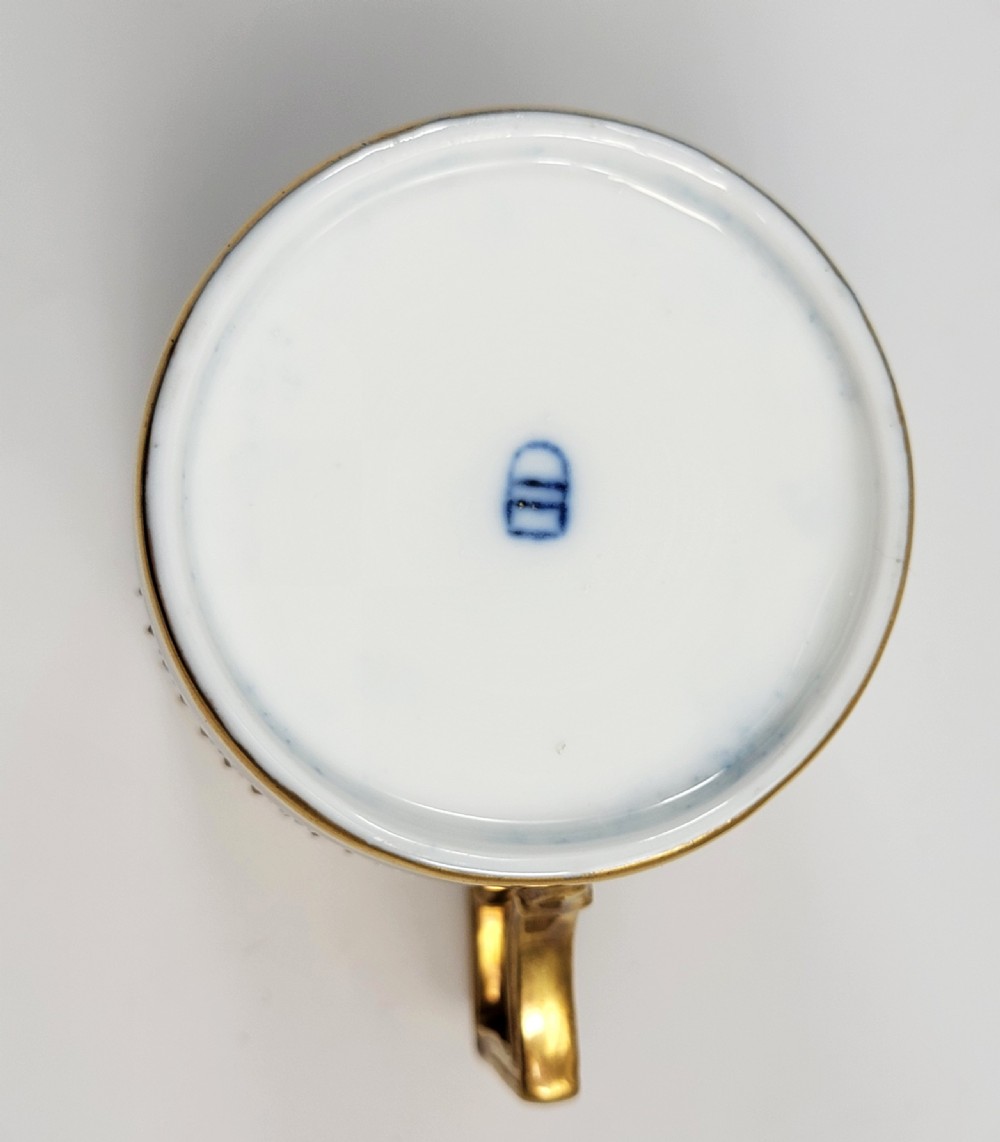 A cobalt blue porcelain covered cup featuring gold leaf scrollwork trim and a hand-painted allegorical woodland vignette with classical figures. View IX
