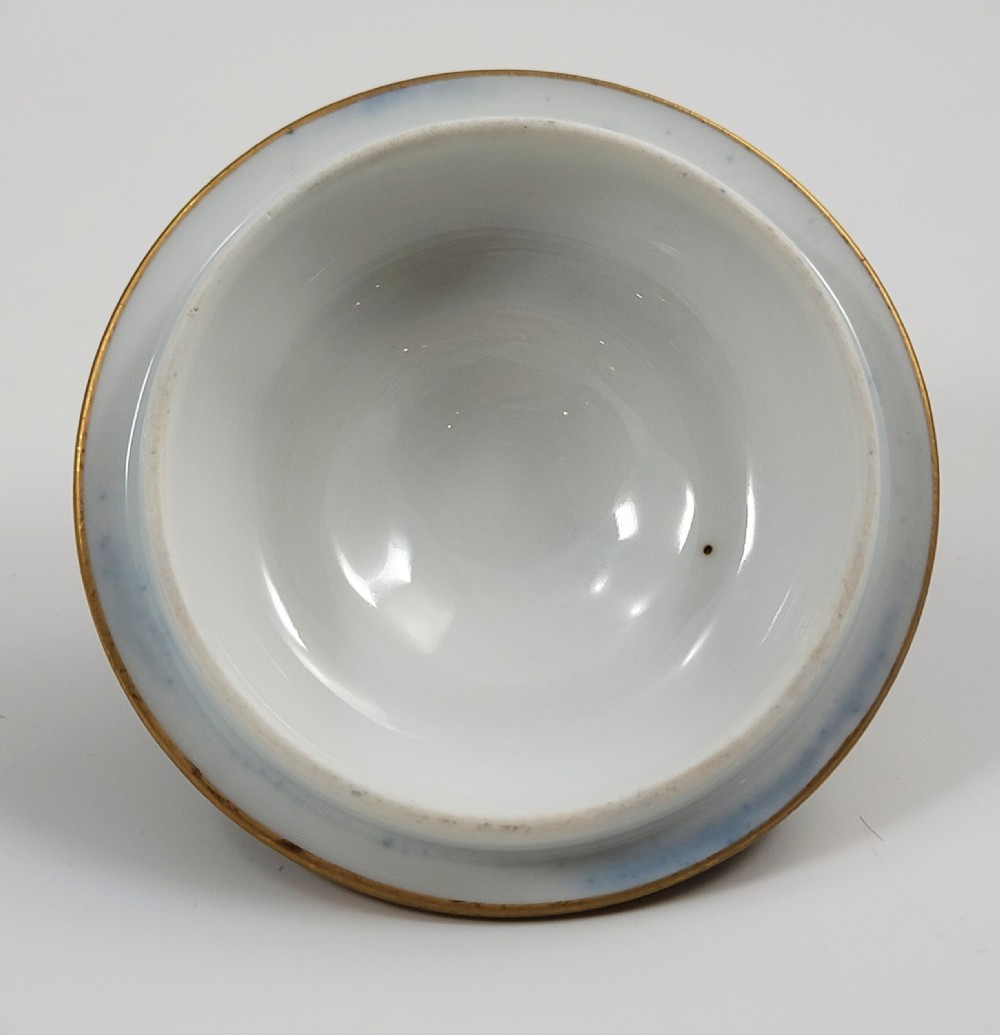 A cobalt blue porcelain covered cup featuring gold leaf scrollwork trim and a hand-painted allegorical woodland vignette with classical figures. View X