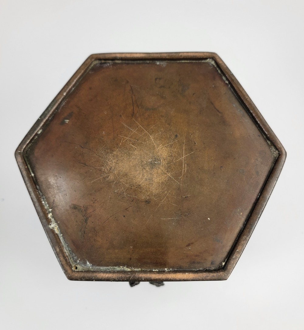 A dark patinated hexagonal bronze incense burner featuring floral relief panels and topped with a sculpted Fu lion finial. View IX