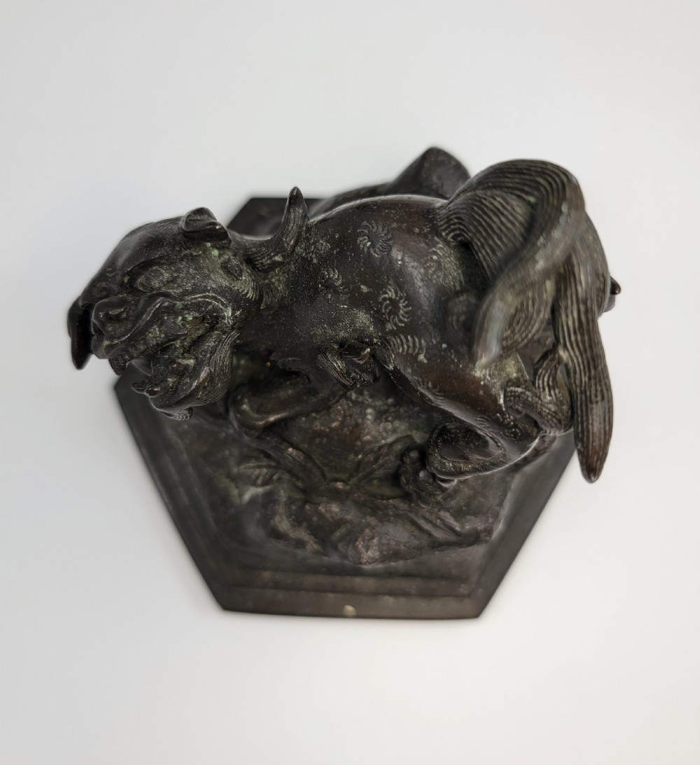 A dark patinated hexagonal bronze incense burner featuring floral relief panels and topped with a sculpted Fu lion finial. View X