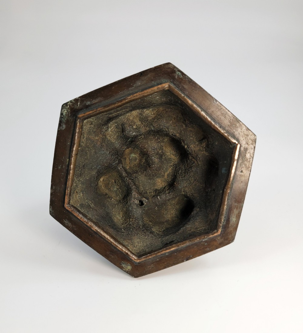 A dark patinated hexagonal bronze incense burner featuring floral relief panels and topped with a sculpted Fu lion finial. View XI