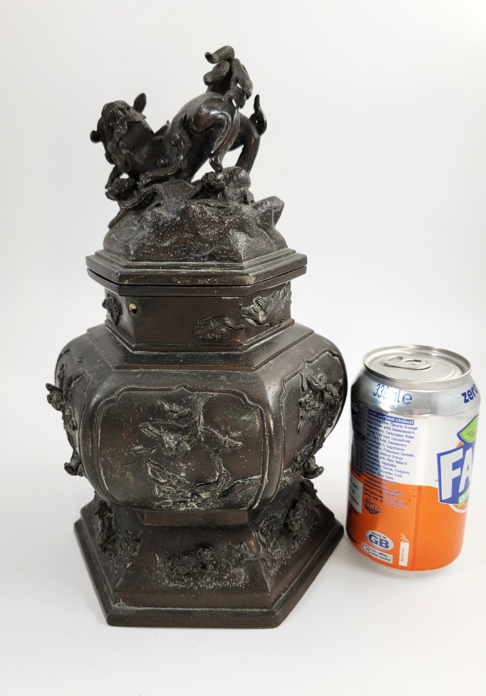 A dark patinated hexagonal bronze incense burner featuring floral relief panels and topped with a sculpted Fu lion finial. View XII