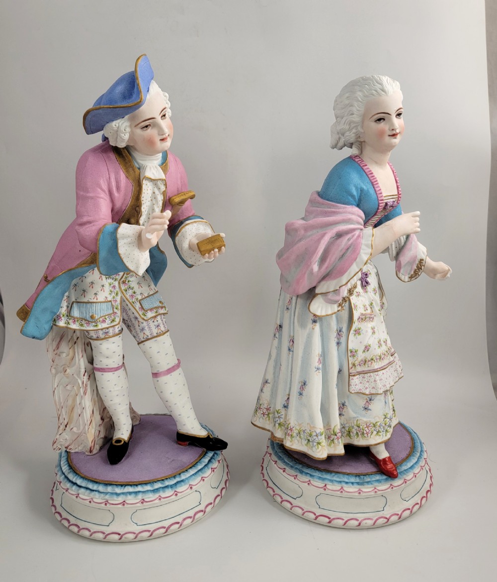 A pair of late 19th-century French biscuit porcelain figures depicting an 18th-century courtly man and woman with pastel pink and blue painted garments. View VI