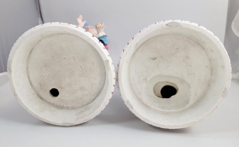 A pair of late 19th-century French biscuit porcelain figures depicting an 18th-century courtly man and woman with pastel pink and blue painted garments. View IX